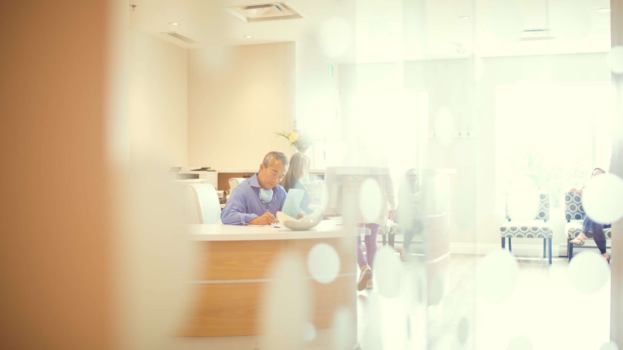 Dr Simon Pong filling in charts at the front desk